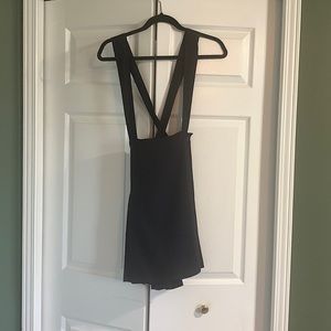 Navy blue pleated suspender pinafore skirt.